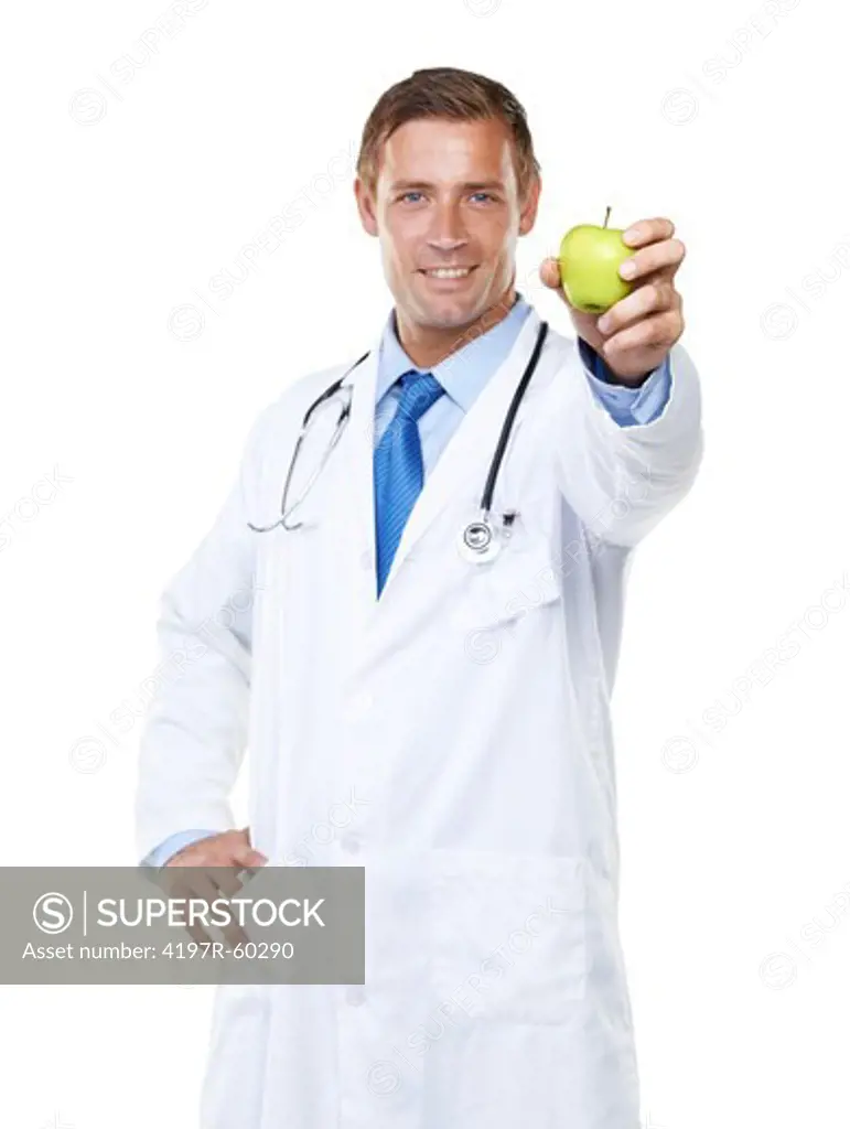 Studio portrait of a confident young doctor holding an apple towards the camera isolated on white