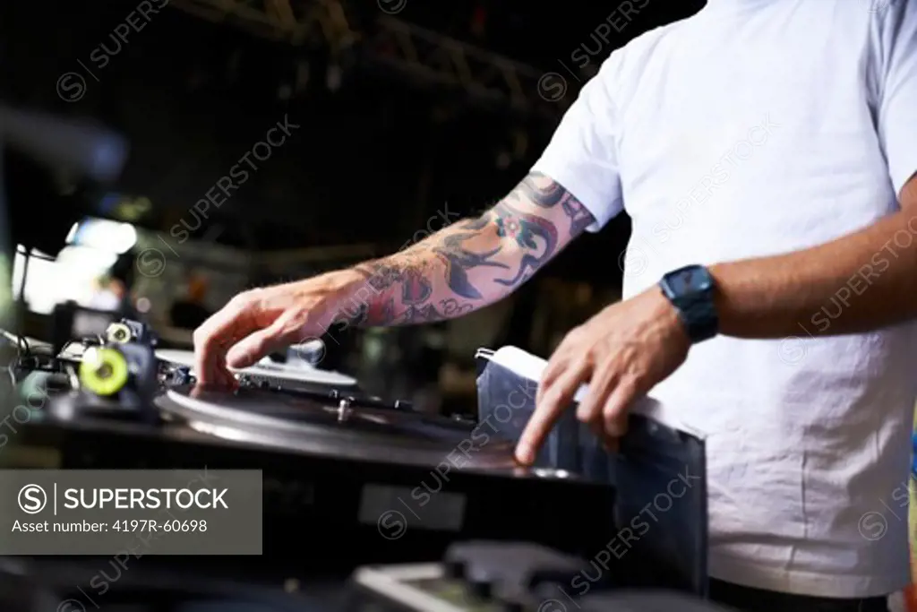 Cropped view of a DJ mixing music on a turntable