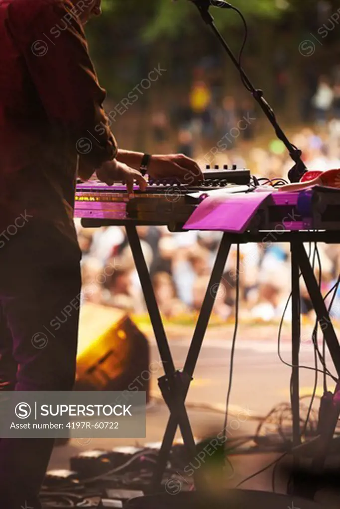 Cropped view of the keyboard player in a band playing at a gig