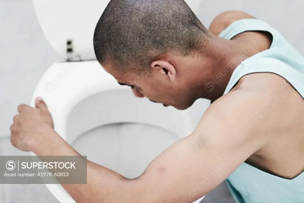 A young drug addict vomiting in the toilet after a drug binge