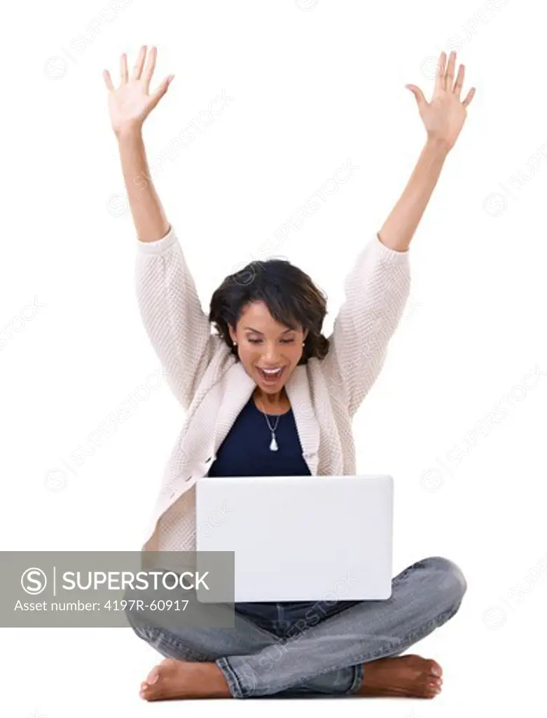 A young woman cheering while sitting with her laptop