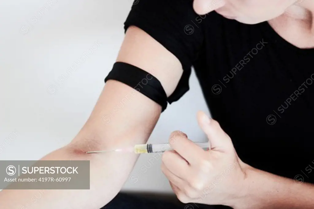 A young woman injecting heroin into her arm