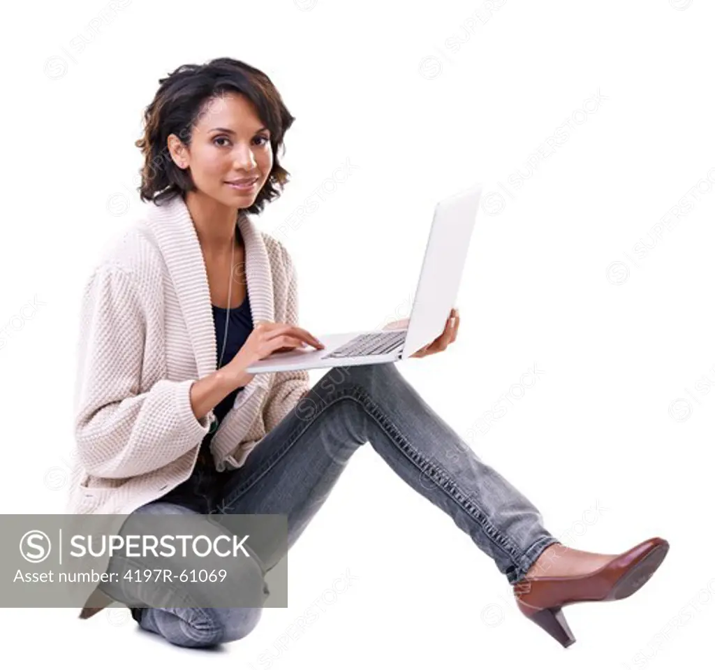 Beautiful young ethnic woman working on her laptop and smiling at the camera - isolated