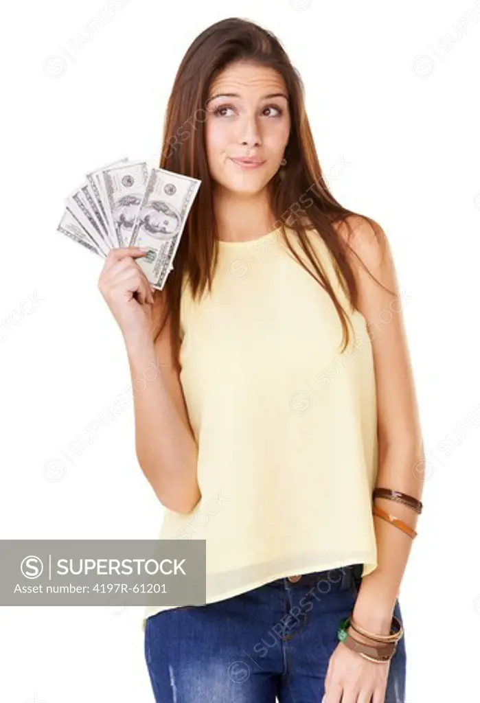 Studio shot of an young woman holding up fanned out banknotes isolated on white