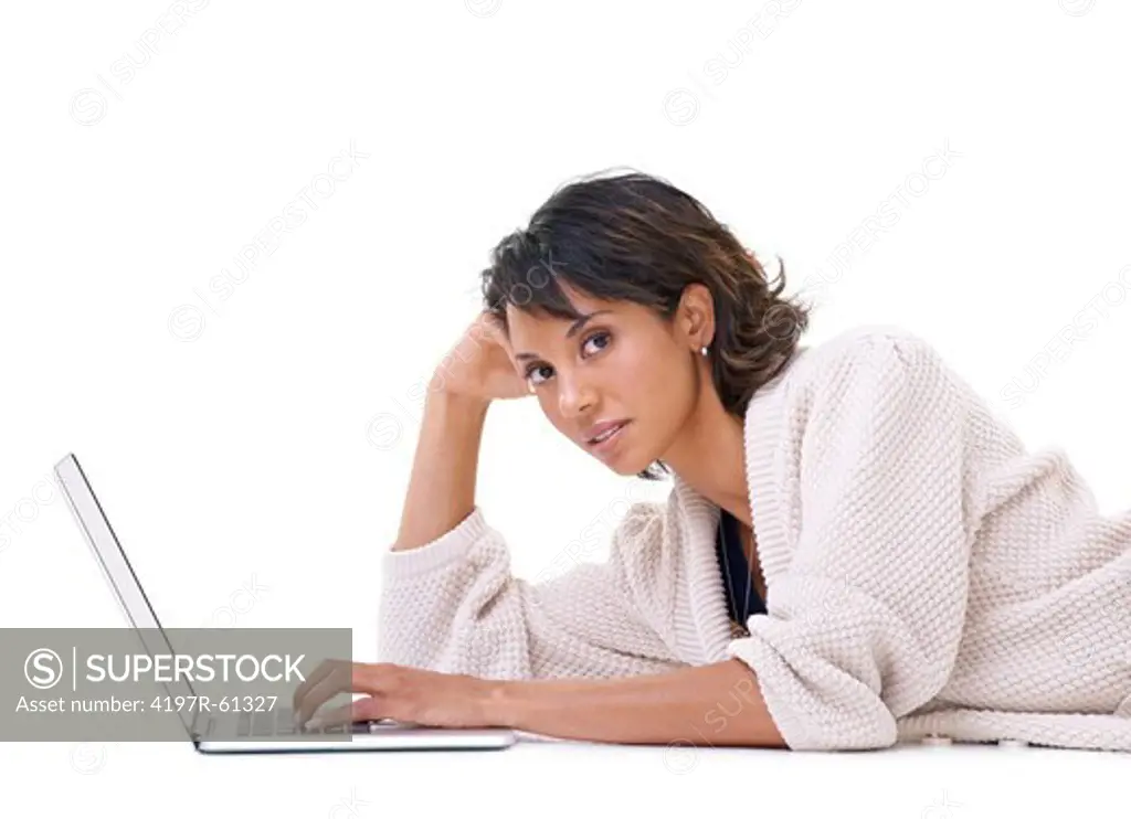 Portrait of a serious young woman lying down and relaxing with her laptop