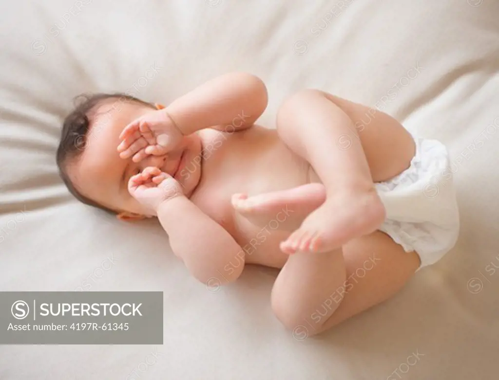 High angle shot of a cute baby lying on a bed
