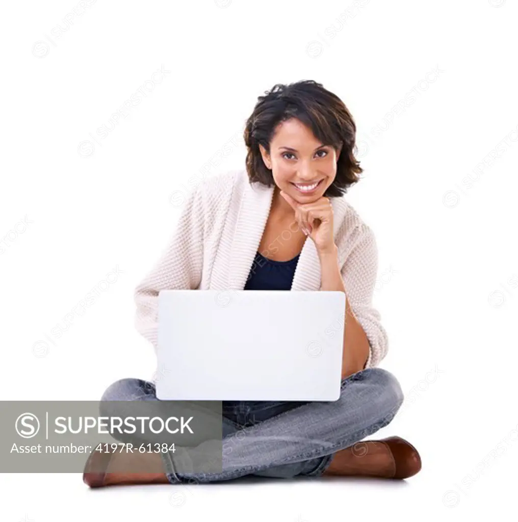 Lovely yougn ethnic woman sitting with a laptop on her lap and smiling at the camera