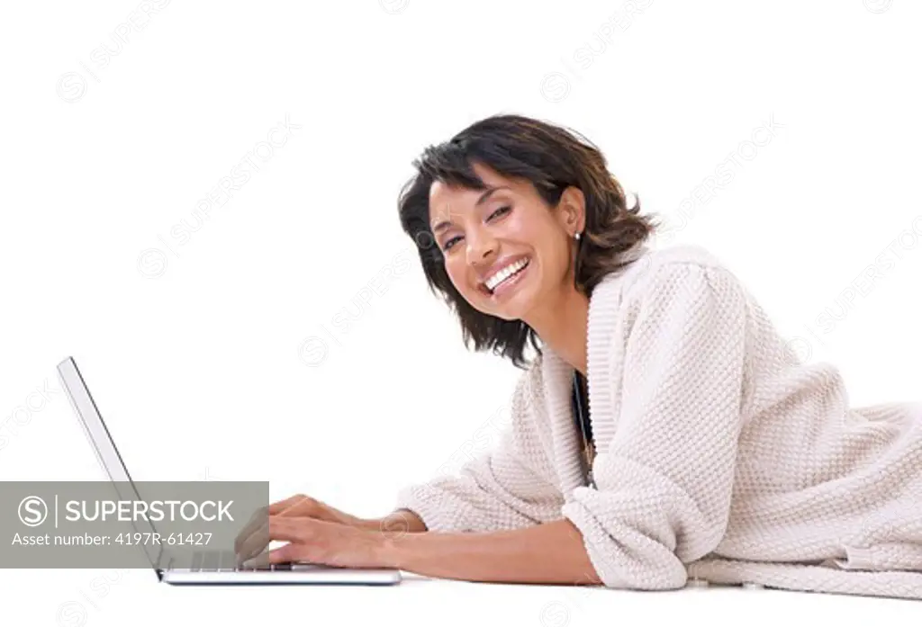Portrait of a young woman smiling while lying down and relaxing with her laptop