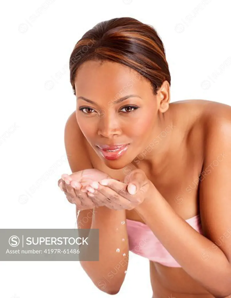 A pretty young woman splashing water on her face