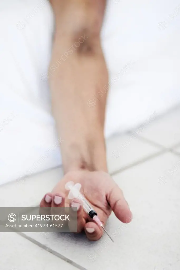 Cropped closeup of a hand holding a syringe - OD/Heroine