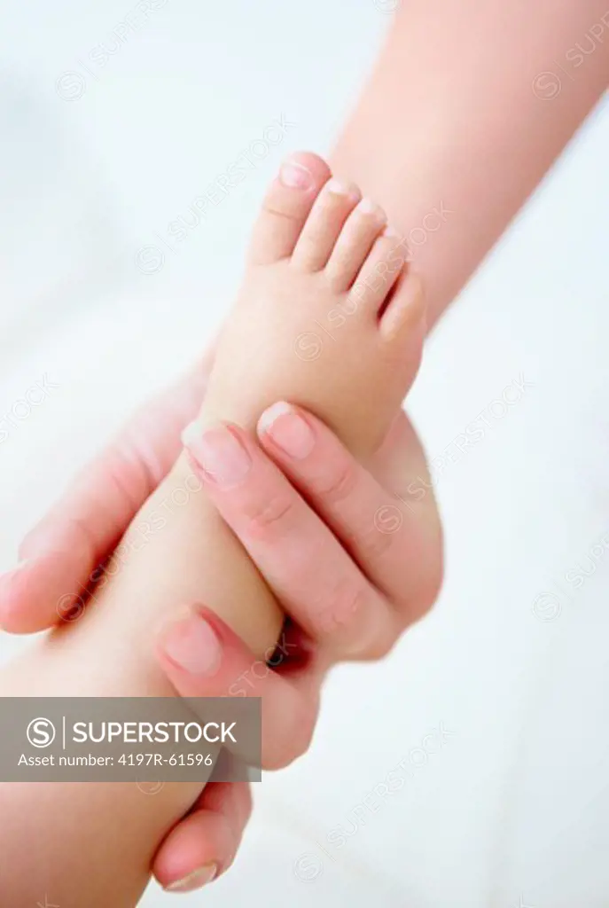 Cropped close up shot of a mother holding her babies foot