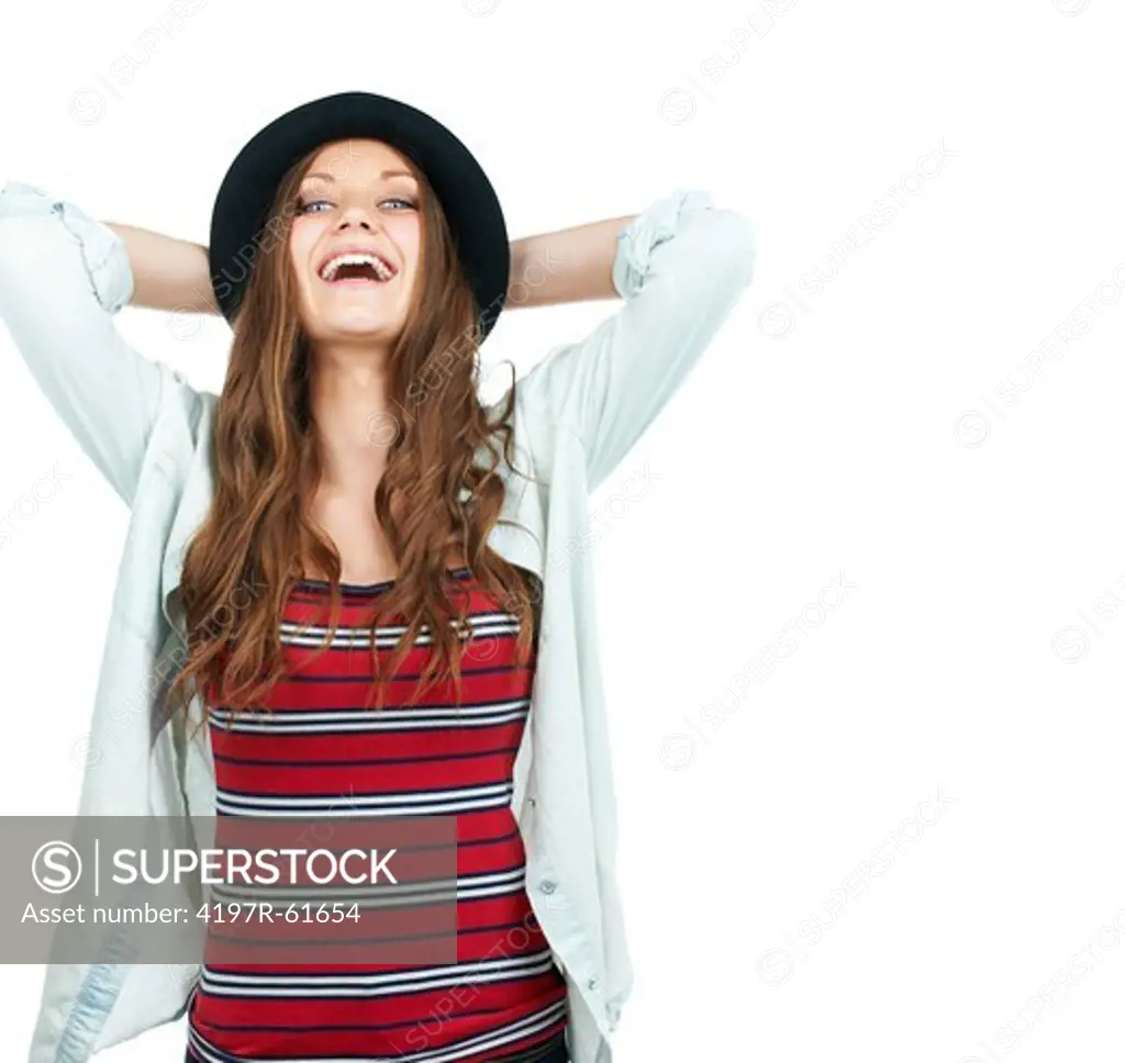 A young woman holding her hat and laughing