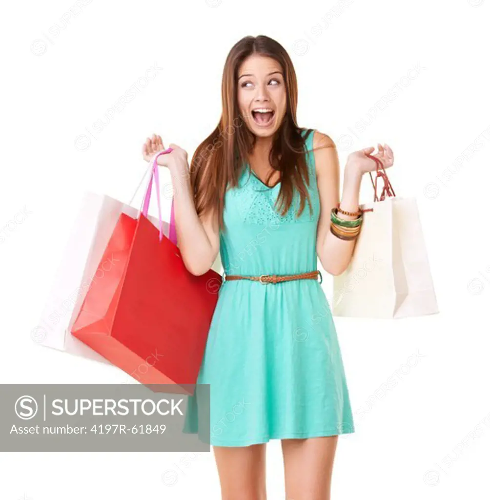 An excited young woman screaming while holding shopping bags against a white background