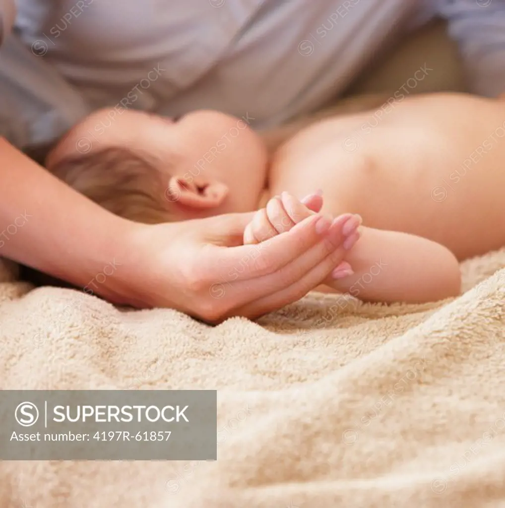 Closeup shot of a slumbering baby being carressed by his mother