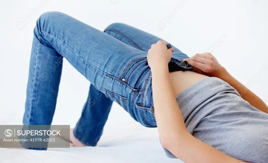 Cropped image of a woman trying to squeeze into her jeans