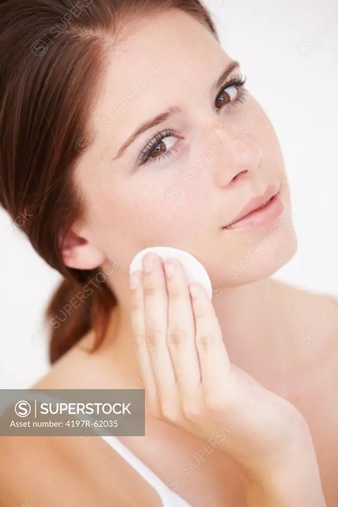 An attractive young woman cleaning her face