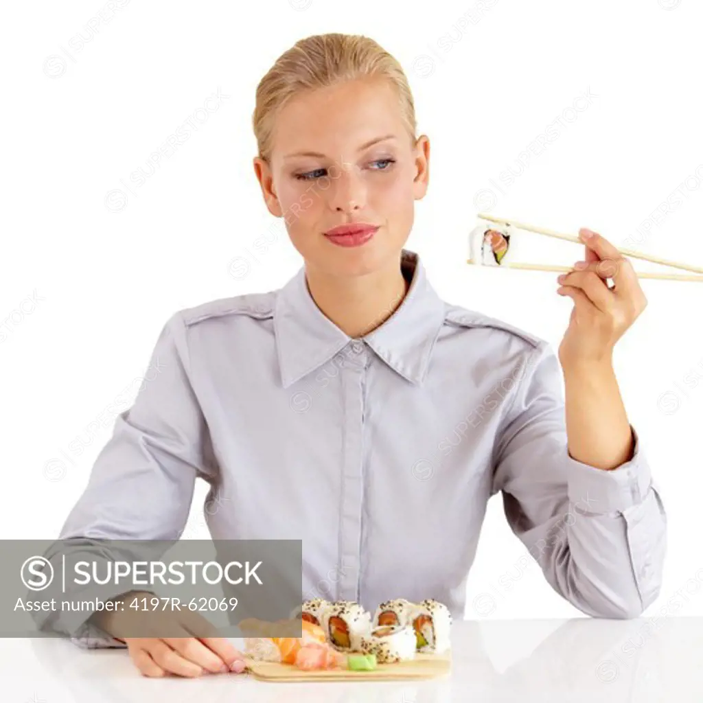 An attractive young woman eating portion of sushi