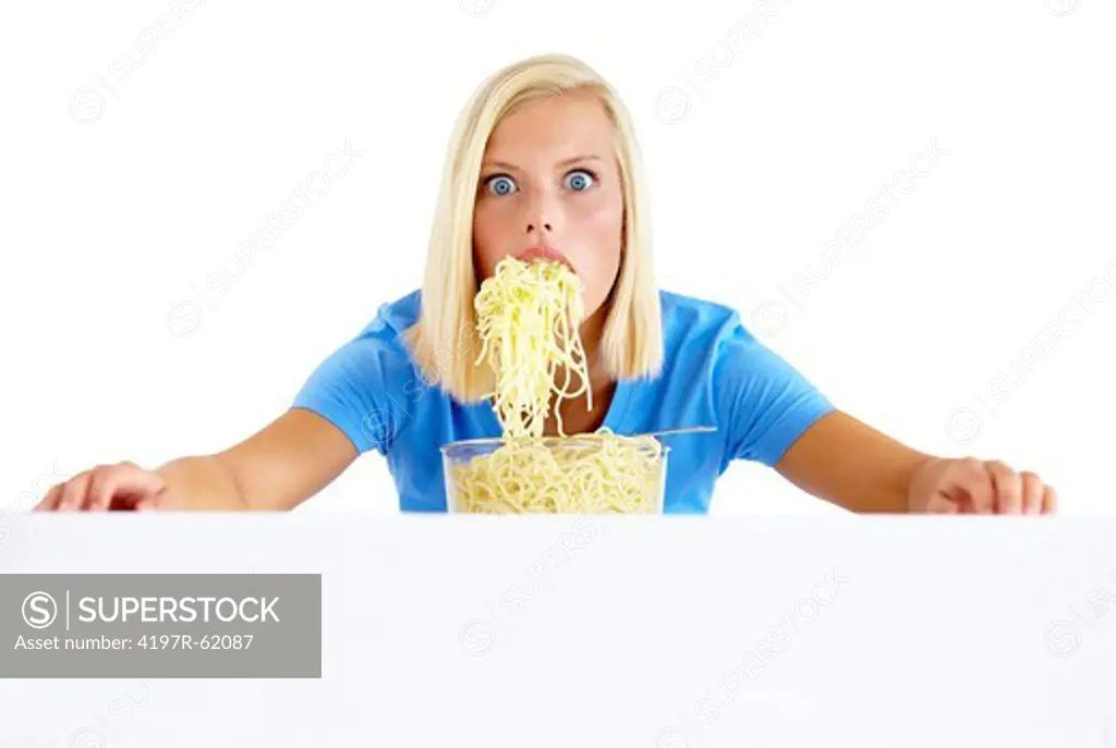Portrait of a young woman scoffing a bowl of pasta