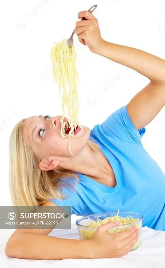 A beautiful young woman eating an entire bowl of pasta alone