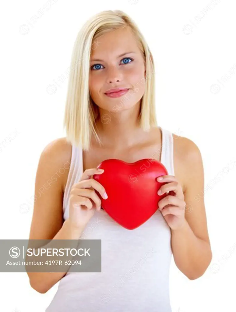 Studio portrait of a young woman holding a heart against her chest and looking at the camera isolated on white