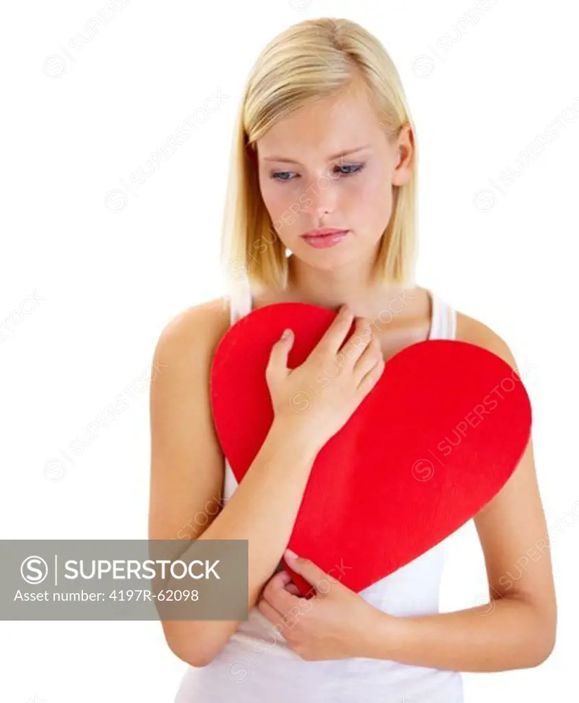 Studio shot of a sad-looking young woman holding a love-heart isolated on white