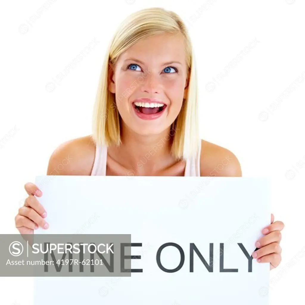 Studio shot of a beautiful young woman holding up a sign reading 'MINE ONLY'