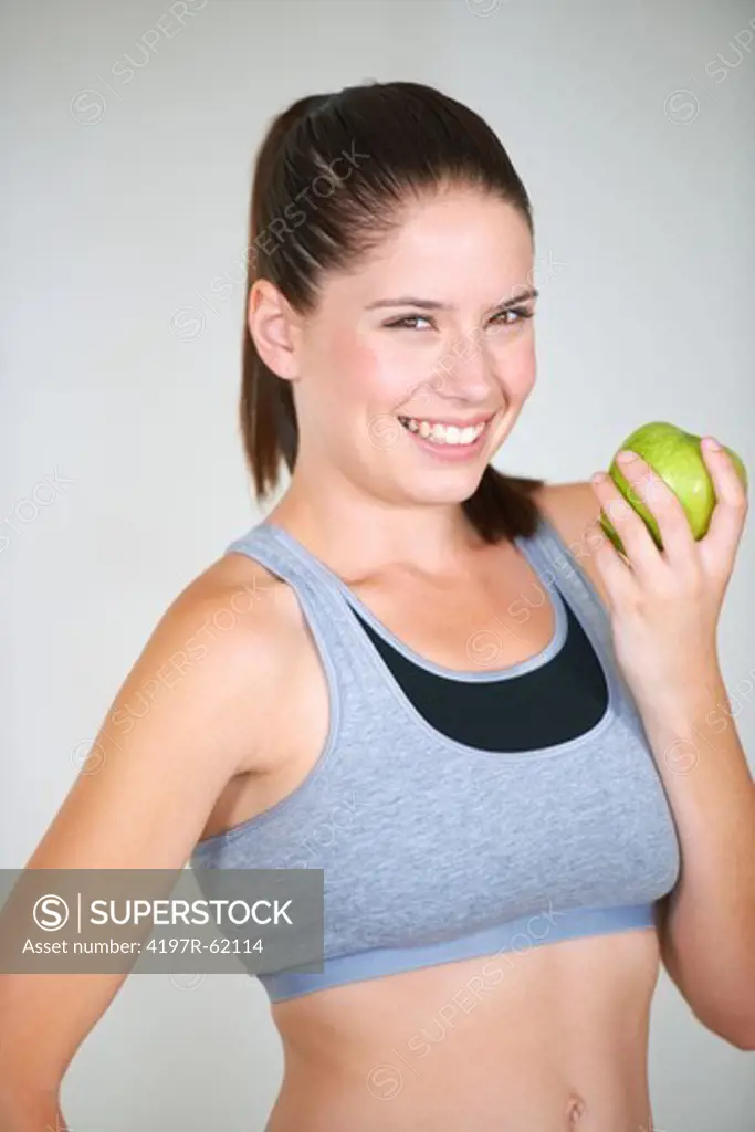 Cute young woman holding a fresh green apple