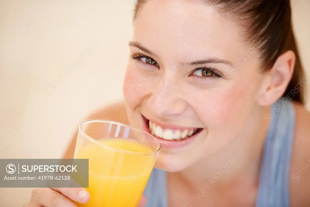 Healthy young woman holding a glass of fresh orange juice