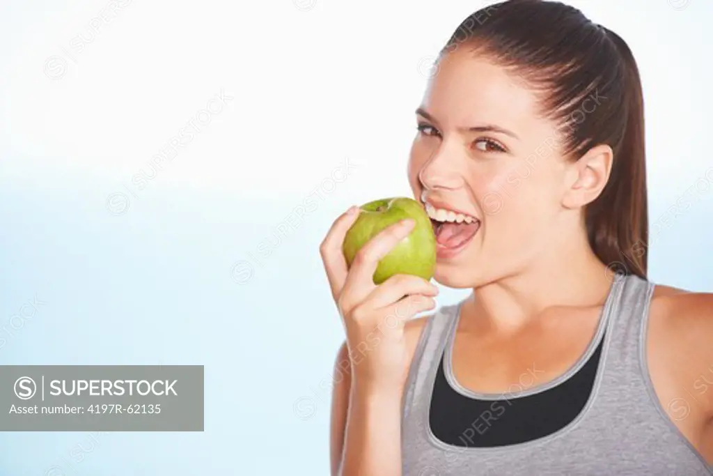 An attractive young woman biting an apple