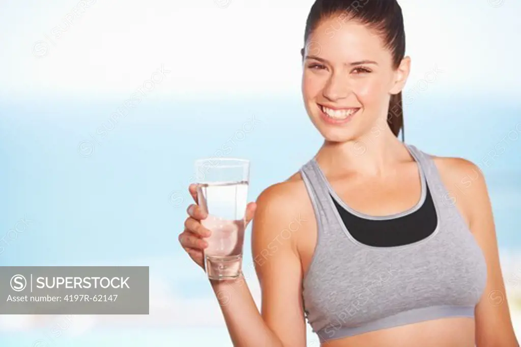 A pretty young woman holding a glass of water