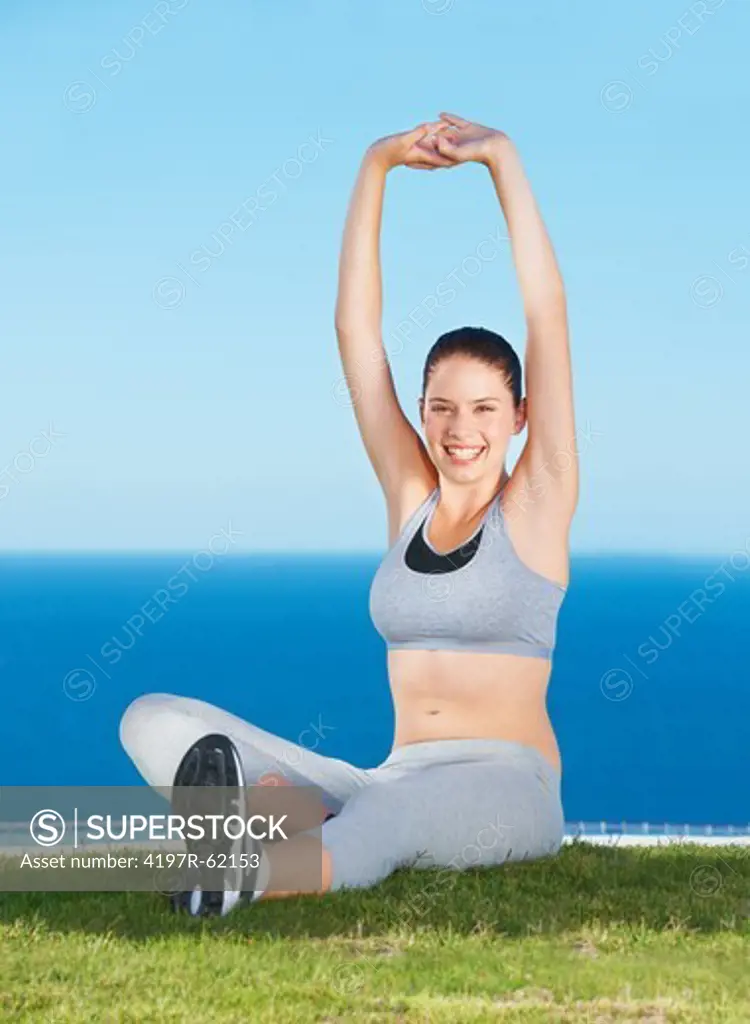 A beautiful young woman stretching on a patch of grass