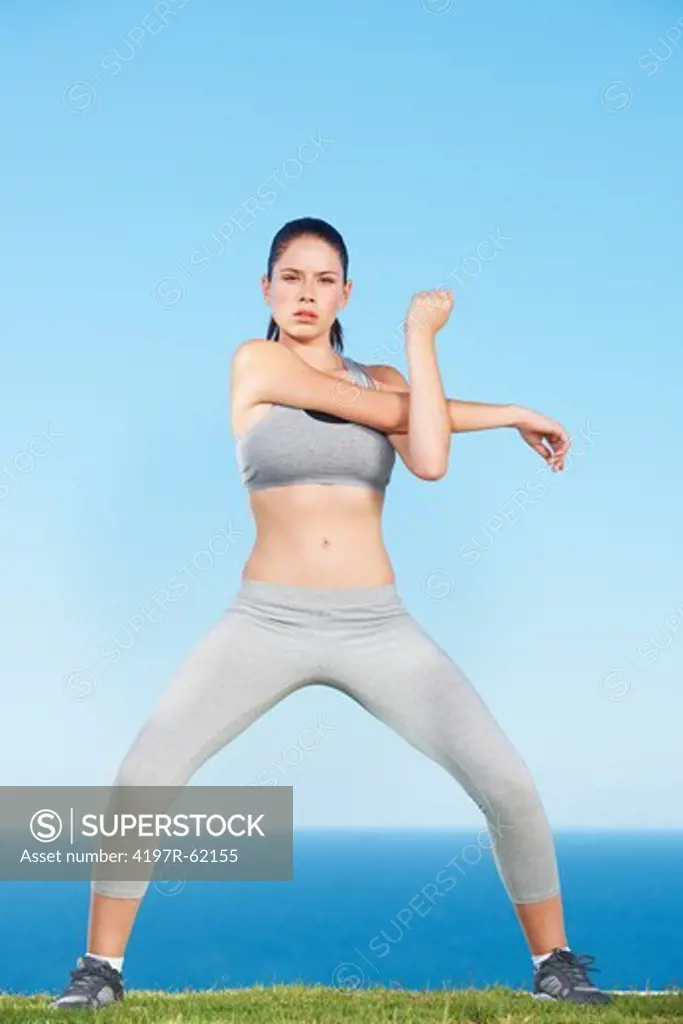 An attractive young woman stretching outside
