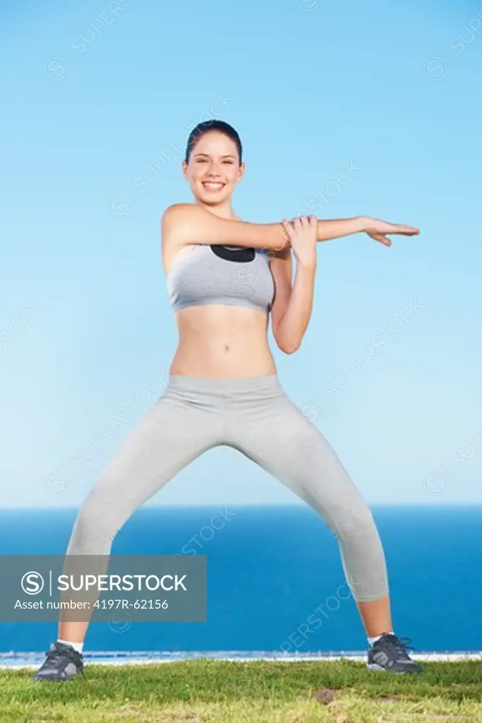 An attractive young woman stretching outside
