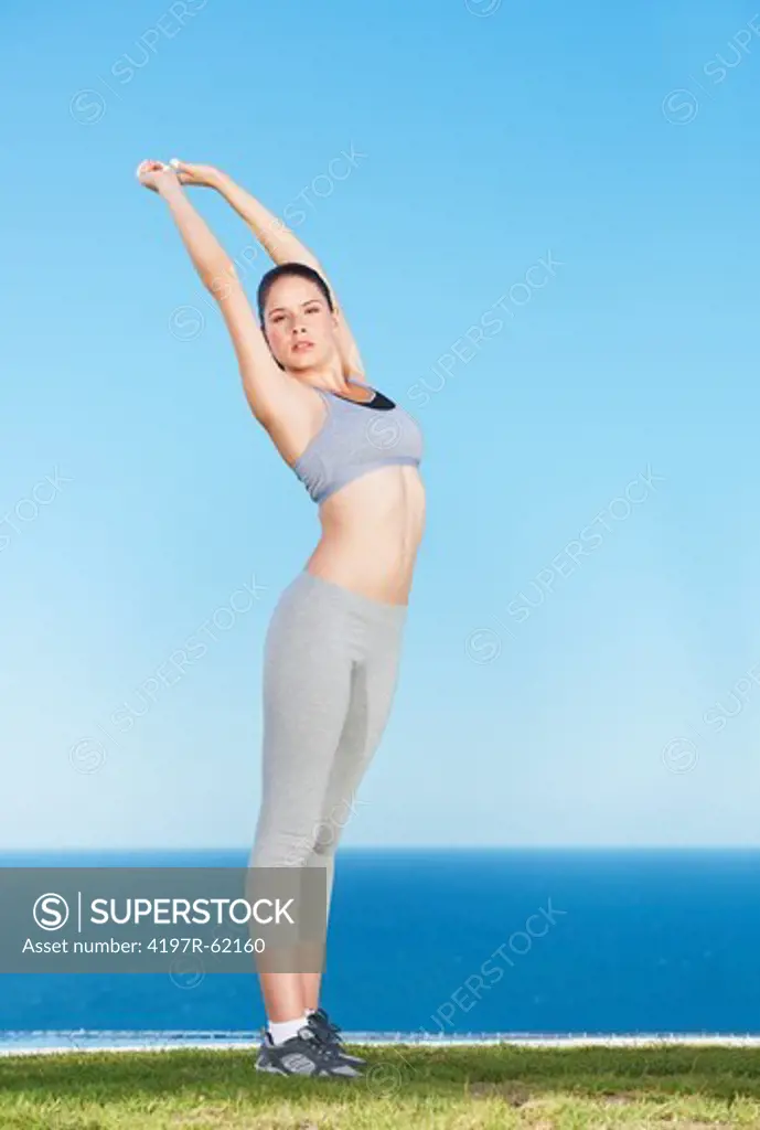 An attractive young woman doing some stretches outside