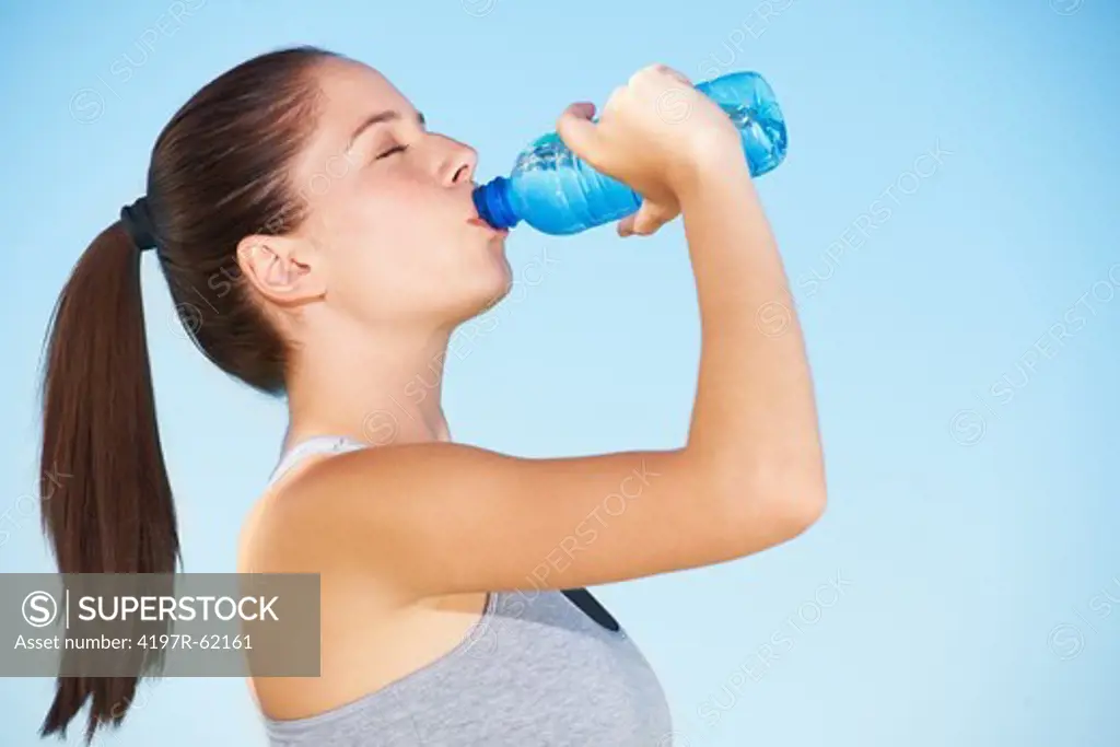 A beautiful young woman drinking a bottle of water
