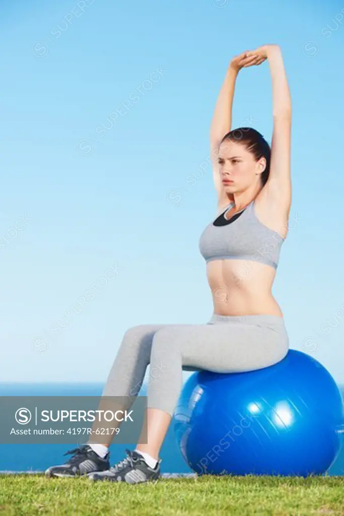 A pretty young woman exercising with weights and a bosu ball