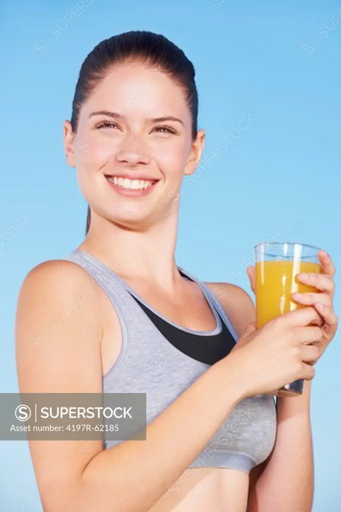An attractive young woman holding a glass of orange juice