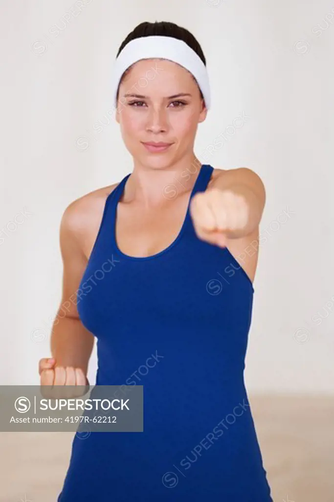 Fit young woman punching towards you
