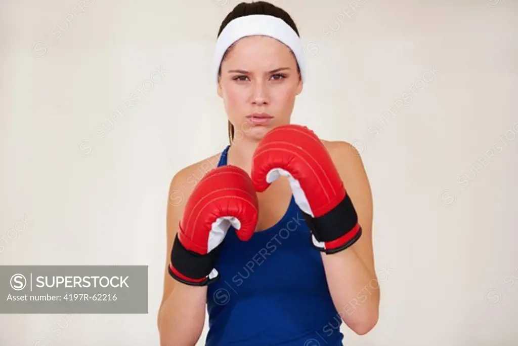 Serious young woman wearing lightweight boxing gloves for a workout