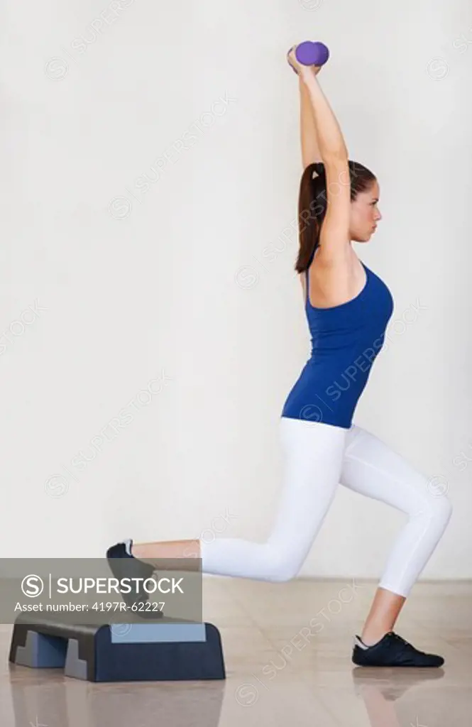 Side view of a young woman working out and doing lunges