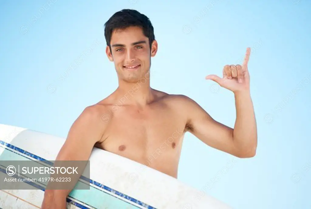 Portrait of a young topless surfer holding his surfboard with the blue sky behind him