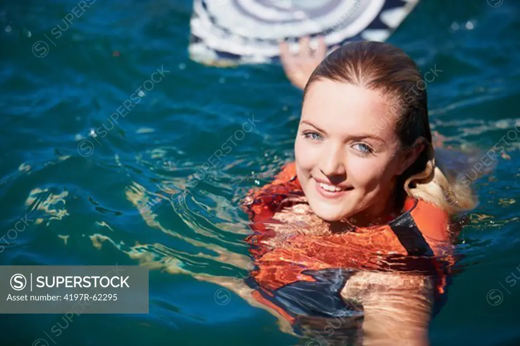 Portrait of a young female wakeboarder floating in the lake