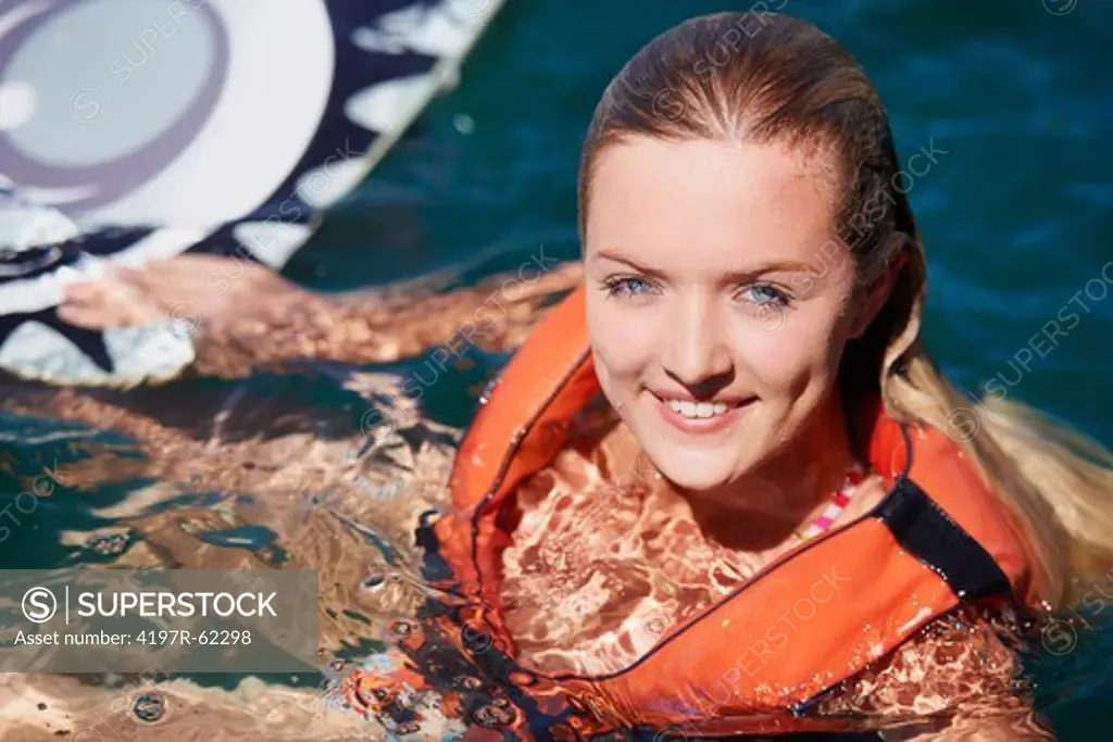 Portrait of a young female wakeboarder floating in the lake