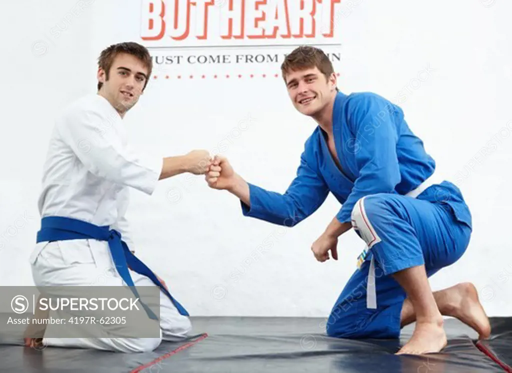 Shot of two young martial arts students being good sports after a sparring match