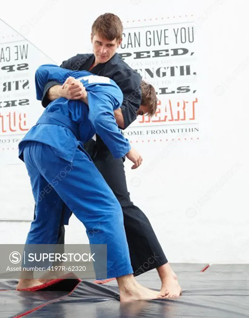 Shot of two young man sparring in a dojo