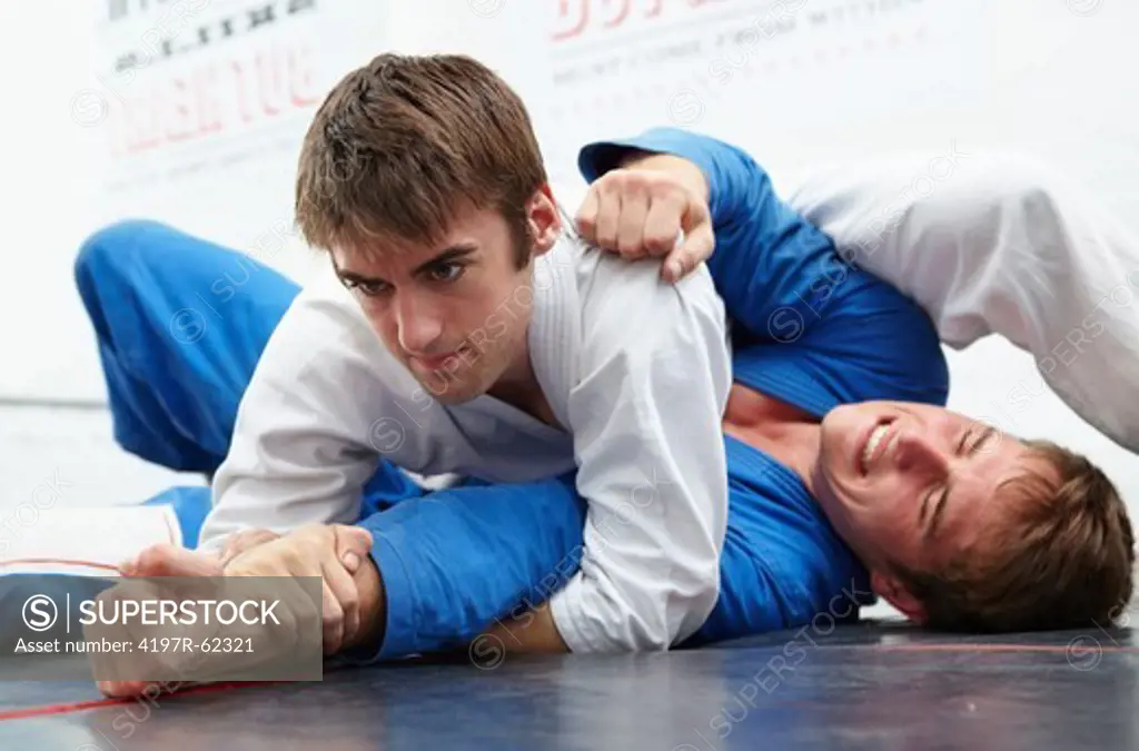 Low angle shot of two young man sparring in a dojo