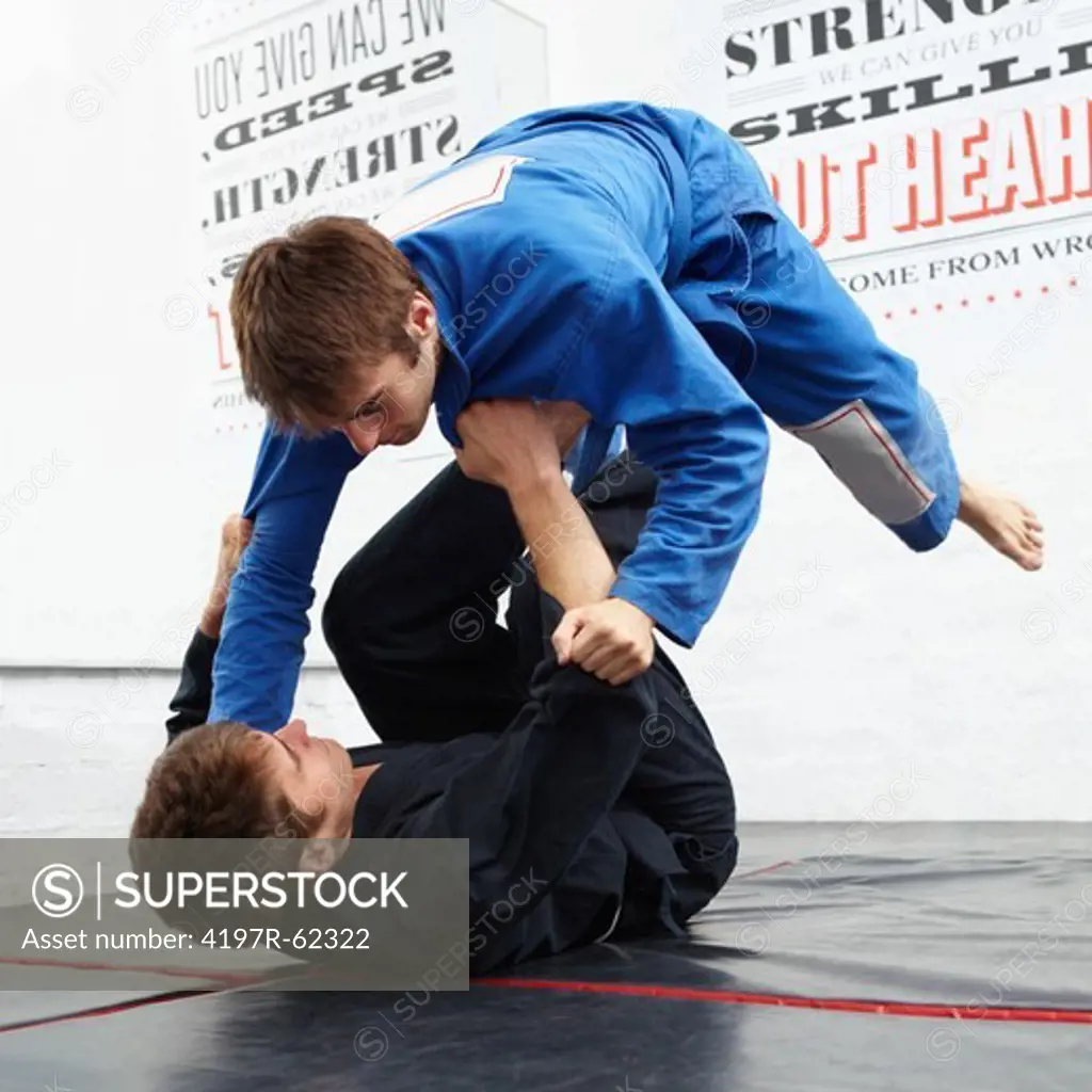 Shot of two young man sparring in a dojo