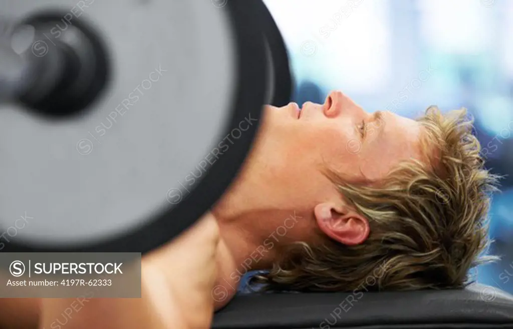 Closeup profile of a man exercising on the bench press