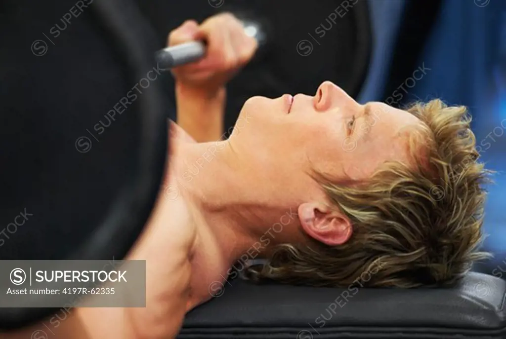 Closeup profile of a man working out on the bench press