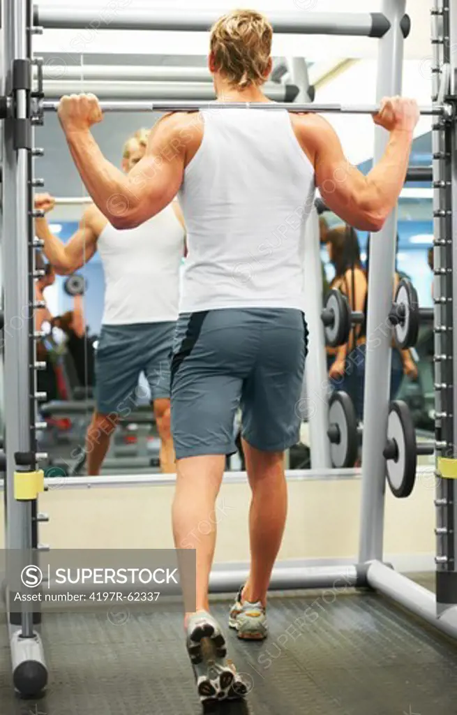 Full length rearview image of a man working out in the gym